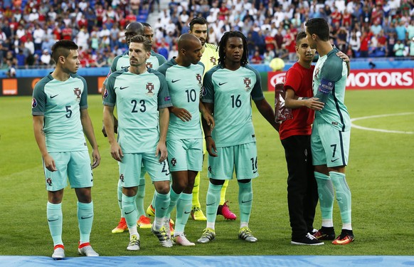 epa05411625 A young man (2nd R) joins Cristiano Ronaldo (R) and his Portuguese teammates on the pitch prior to the UEFA EURO 2016 semi final match between Portugal and Wales at Stade de Lyon in Lyon,  ...