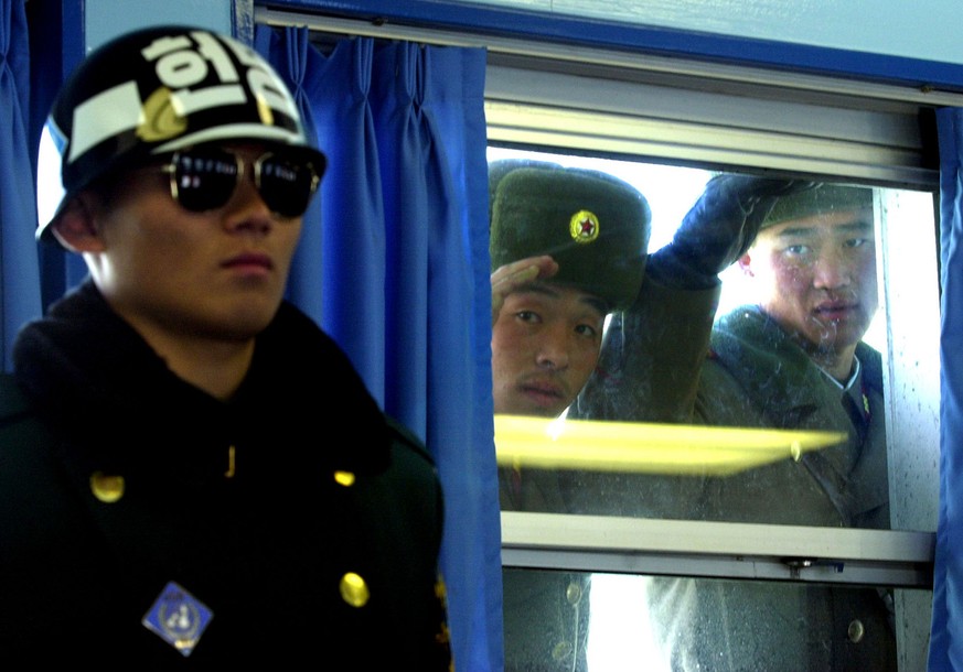 North Korean soldiers look at guarding South Korean soldier in the military armistice commission meeting room at the border village of the Panmunjom, north of Seoul, Wednesday, Dec. 1, 2004. North Kor ...