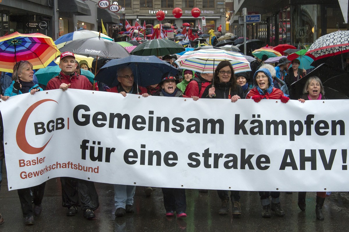 Kundgebungsteilnehmer tragen ein Transparent mit einem Schreibfehler ("fuer eine 'strake' AHV") und Fahnen am traditionellen 1. Mai-Umzug am Tag der Arbeit, in Basel, am Sonntag, 1 ...