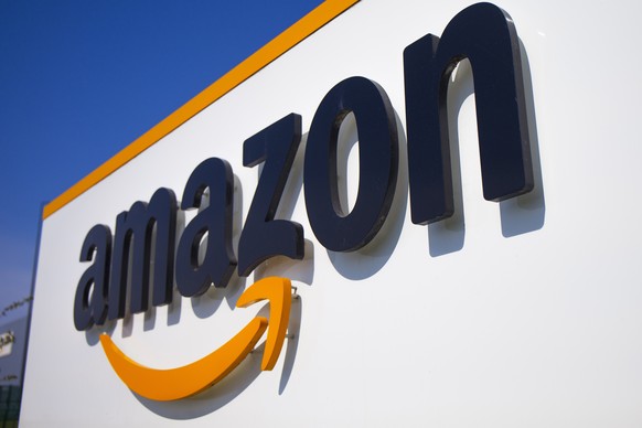 FILE - A company logo is seen at the entrance of Amazon, in Douai, northern France, on April 16, 2020.Amazon has agreed to make major changes to its business practices to settle antitrust investigatio ...