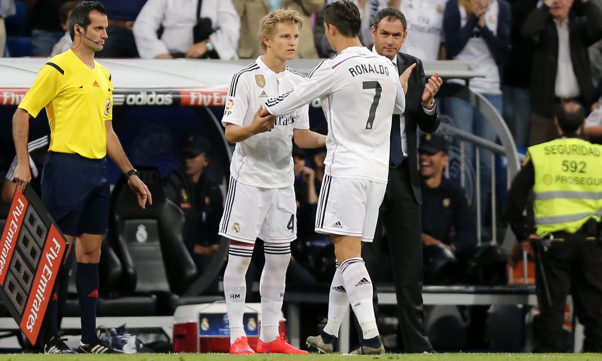 Real Madrid's Cristiano Ronaldo embraces Real Madrid's Martin Odegaard from Norway, center left, as he leaves the field during a Spanish La Liga soccer match between Real Madrid and Getafe a ...