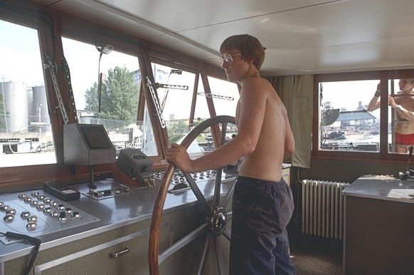 Ein Matrosen-Lehrling am Haspel (Steuerrad) eines Schleppers auf dem Rhein in Basel, 1985.