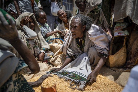 FILE - An Ethiopian woman argues with others over the allocation of yellow split peas after it was distributed by the Relief Society of Tigray in the town of Agula, in the Tigray region of northern Et ...