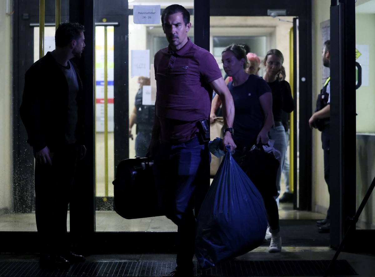 epa11563647 Officers carrying bags leave a refugee center during a police search, in Solingen, Germany, 24 August 2024. A man stabbed passers-by at random with a knife during the city festival in Soli ...