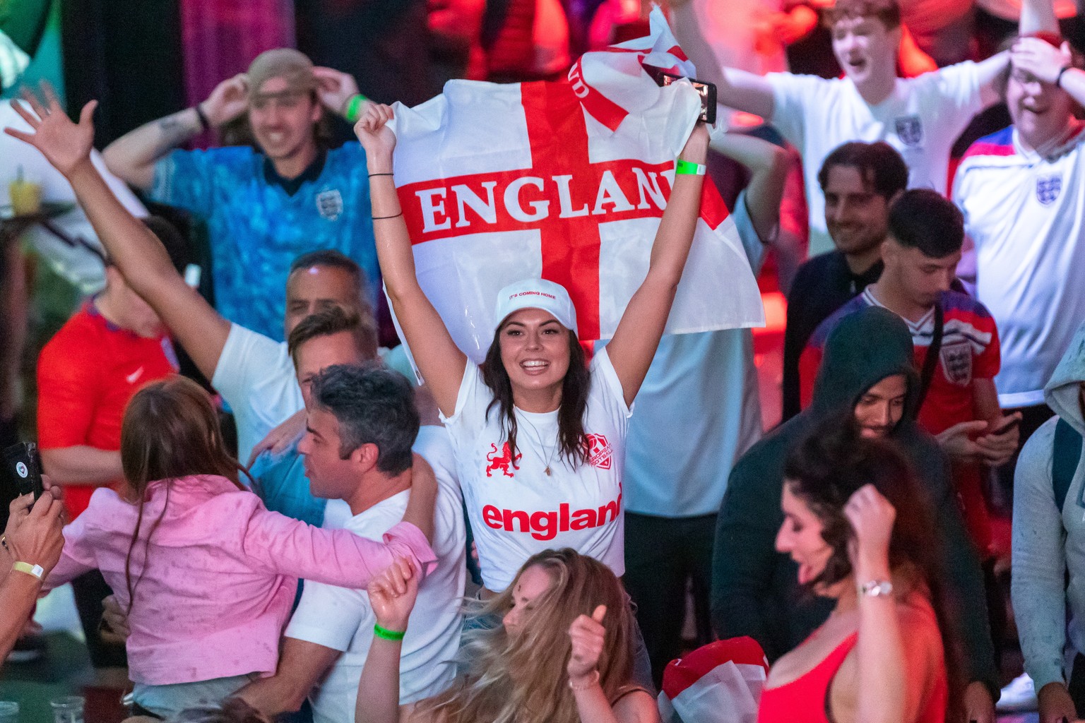 epa09330593 England supporters celebrate England reaching the final after watching a public viewing of the UEFA EURO 2020 semi final soccer match between England and Denmark, in Boxpark, Croydon, Lond ...