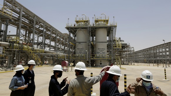 FILE - Saudi Aramco engineers and journalists look at the Hawiyah Natural Gas Liquids Recovery Plant in Hawiyah, in the Eastern Province of Saudi Arabia on June 28, 2021. Saudi oil company Aramco