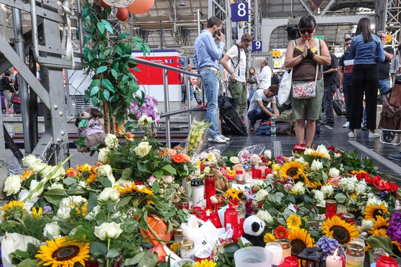 epaselect epa07748280 A woman pays tribute at the main train station in Frankfurt am Main, Germany, 30 July 2019, one day after an eight-year-old boy died after being pushed onto the rail tracks in fr ...