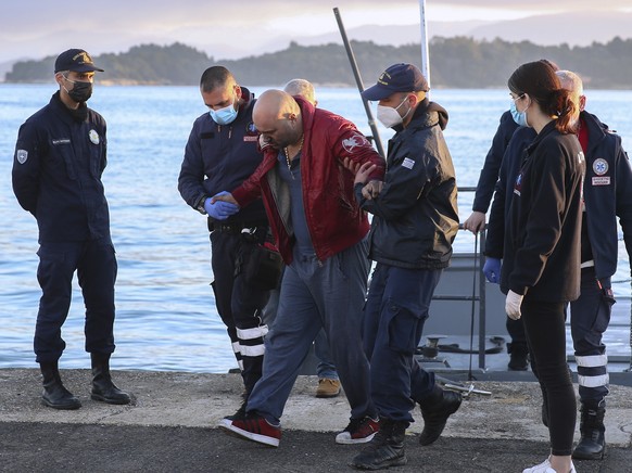 A slightly injured man helped by coast guard officers, arrives at the port of Corfu island, northwestern Greece, after the evacuation of a ferry, Friday, Feb. 18, 2022. More than 280 people have been  ...