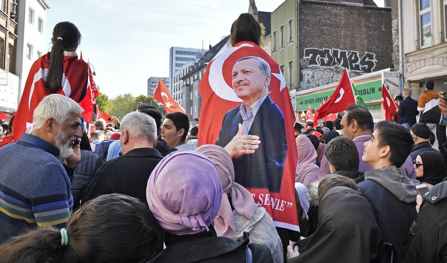 Erdogan supporters gather in a street near the new central mosque to catch a sight of the Turkish president in Cologne, Germany, Saturday, Sept. 29, 2018. Turkish President Recep Tayyip Erdogan is on  ...