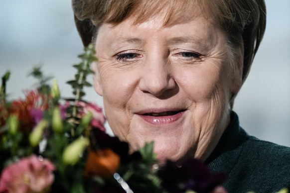 epa08210602 German Chancellor Angela Merkel is presented with flowers by the national gardeners association on the occasion of valentine&#039;s day at the chancellery in Berlin, Germany, 11 February 2 ...