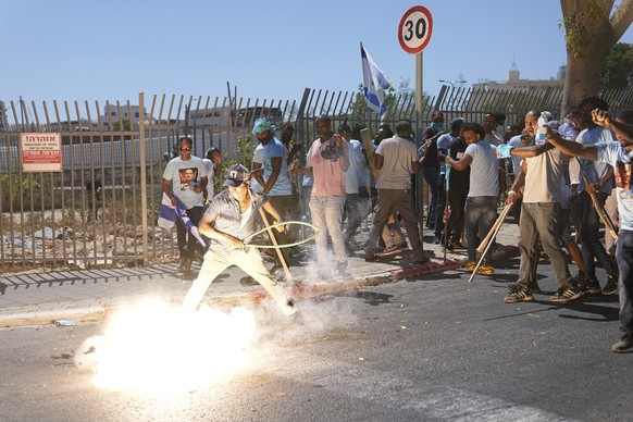 A stun grenade thrown by Israeli police explodes next to Eritrean protesters during a protest against an event organized by the Eritrea Embassy, ​​in Tel Aviv, Israel, Saturday, September 2, 2023. Hundreds of ...