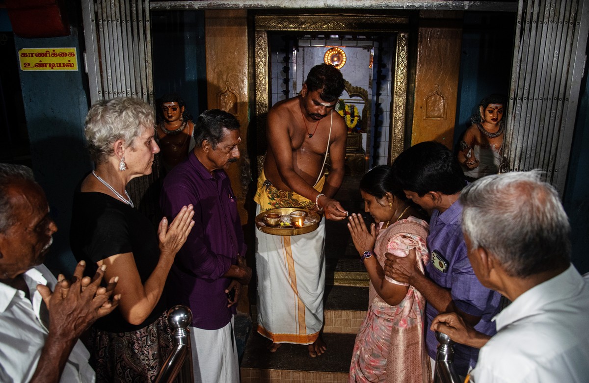 epa11702866 A Indian priest distributes prasad or sweets after a prayer for good luck to Kamala Harris' in Thulasendrapuram, the ancestral village of US Vice President and Democratic presidential ...