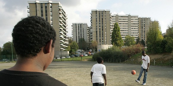 French boys play soccer in a waste ground by their low cost housing complex, Monday, Nov. 7,2005, in Grigny, a suburb south of Paris where, for the first time since the start of the urban violence, po ...