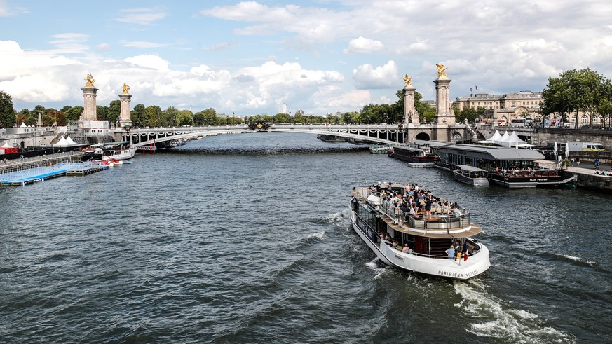 epa10784668 A boat with tourists sails on the Seine river in Paris, France, 04 August 2023. A training session for athletes participating in the Open Water World Cup was canceled as the water quality  ...