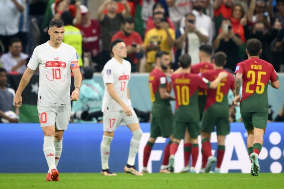 Switzerland's midfielder Granit Xhaka, left, reacts after the Portugal's third goal during the FIFA World Cup Qatar 2022 round of 16 soccer match between Portugal and Switzerland at the Lusa ...