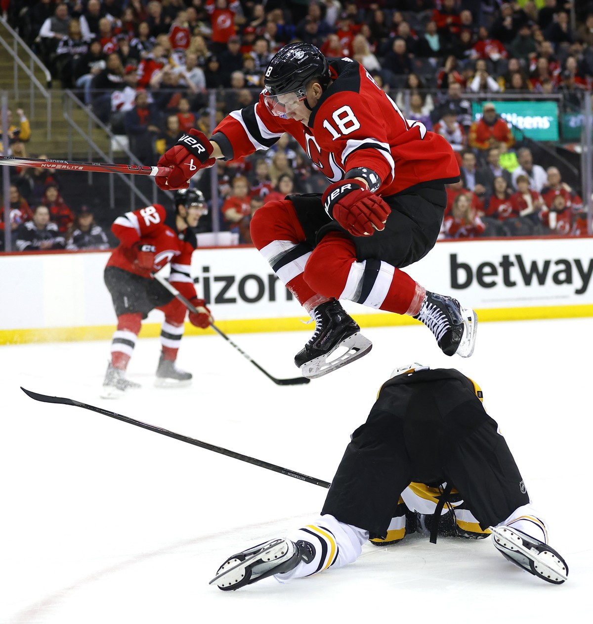 New Jersey Devils left wing Ondrej Palat (18) leaps over Pittsburgh Penguins defenseman Marcus Pettersson (28) during the second period of an NHL hockey game, Tuesday, April 2, 2024, in Newark, N.J. ( ...