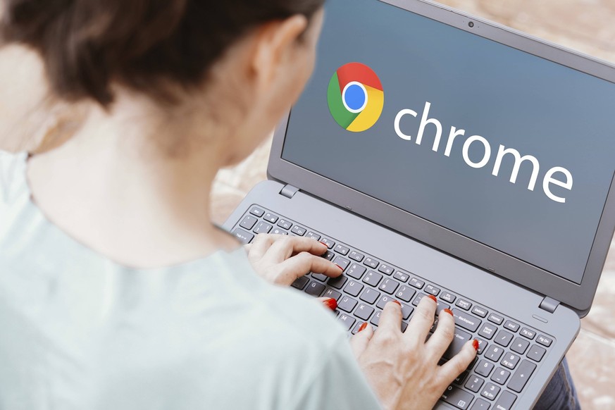 Frau vor Laptop mit Google Chrome (Logo). Symbolbild.