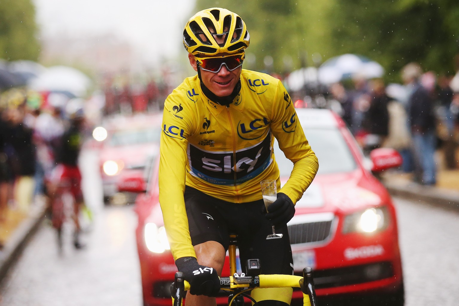 Locker-flockig fährt Chris Froome mit dem Glas in der Hand ins Ziel der letzten Etappe.&nbsp;