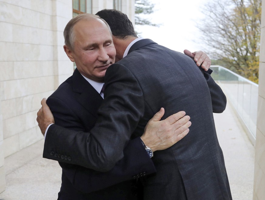 In this Monday, Nov. 20, 2017, photo, Russian President Vladimir Putin, left, hugs with Syrian President Bashar Assad in the Bocharov Ruchei residence in the Black Sea resort of Sochi, Russia. Putin h ...
