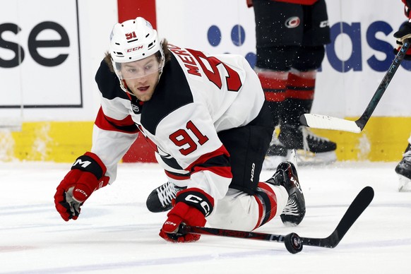 New Jersey Devils&#039; Dawson Mercer (91) keeps the puck in the offensive zone resulting in a goal against the Carolina Hurricanes during the first period of Game 2 of an NHL hockey Stanley Cup first ...