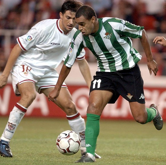 Real Betis&#039; Brazilian player Denilson, center, dribbles the ball between Seville&#039;s Pabro Alfaro, right, and Marti in a Spanish league soccer match in Seville, Spain Sunday Oct. 19, 2003. (AP ...