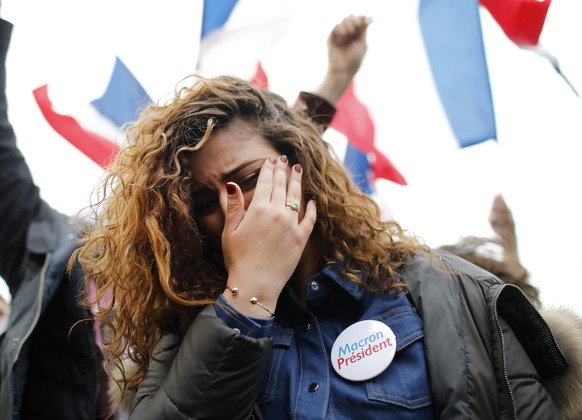 A supporter of French independent centrist presidential candidate, Emmanuel Macron reacts outside the Louvre museum in Paris, France, Sunday, May 7, 2017. Polling agencies have projected that centrist ...