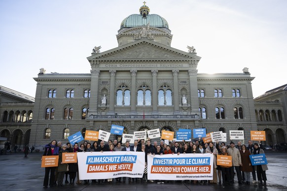 Parlamentarier der SP und der Gruenen posieren mit Transparenten vor dem Bundeshaus waehrend einer Fotoaktion zur Klimafonds-Initiative, nach der Wintersession der Eidgenoessischen Raete, am Dienstag, ...