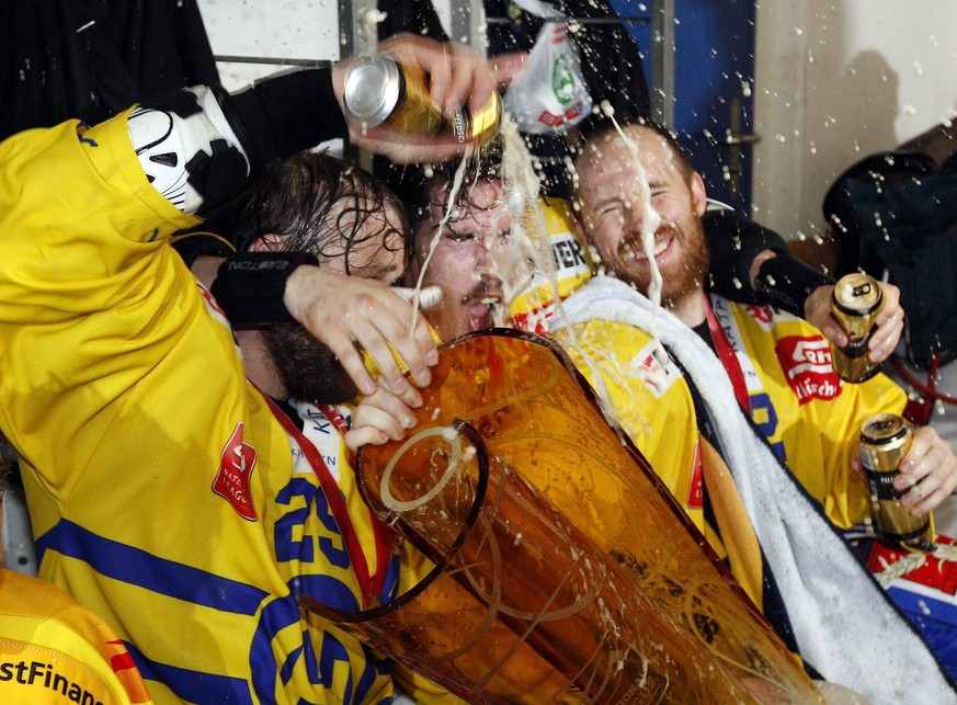 (L-R) HC Davos Verteidiger Beat Forster, Dario Buergler und Lee Jinman feiern den Sieg in der Garderobe nach dem sechsten Eishockey Playoff Finalspiel der National League A zwischen den Kloten Flyers  ...