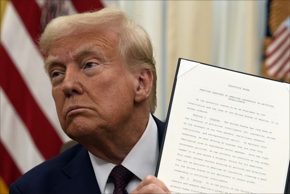 President Donald Trump holds up a signed executive order regarding cryptocurrency in the Oval Office of the White House, Thursday, Jan. 23, 2025, in Washington. (AP Photo/Ben Curtis)
Donald Trump