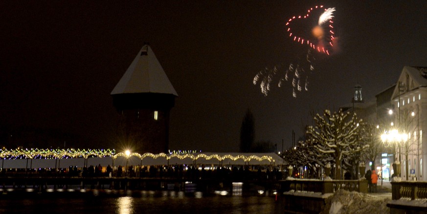 Mit einem Feuerwerk in Form eines Herzes neben der Kappelerbruecke wird in der Stadt Luzern das neue Jahr begruesst am Freitag, 1. Januar 2015. (KEYSTONE/Urs Flueeler)

New year fireworks in form of ...