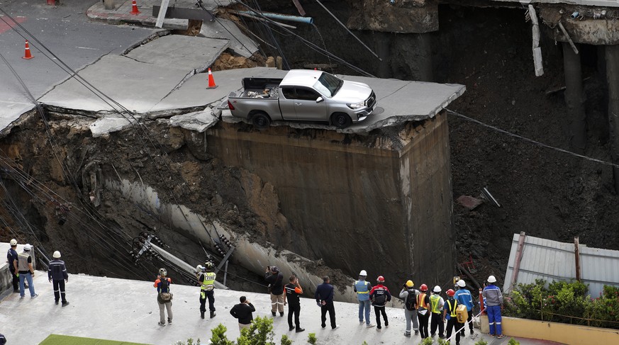 epaselect epa12401072 Thai emergency service personnel and officials inspect a large hole where a vehicle is stuck following a road collapse in Bangkok, Thailand, 24 September 2025. A major street in  ...