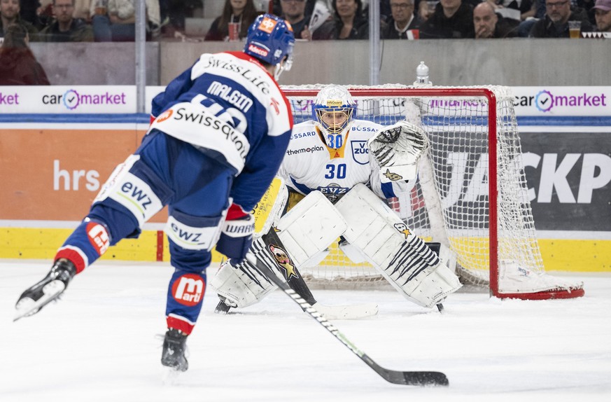 Denis Malgin (ZSC), links, kaempft um den Puck gegen Torhueter Leonardo Genoni (EVZ), rechts, im dritten Halbfinal Playoff Eishockeyspiel der National League zwischen den ZSC Lions und dem EV Zug, am  ...