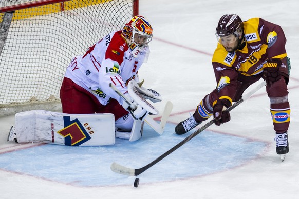 le gardien Harri Saeteri (EHCB), gauche, lutte pour le puck avec Josh Jooris (GSHC), droite, lors du match du championnat suisse de hockey sur glace de National League entre Geneve-Servette HC, GSHC,  ...