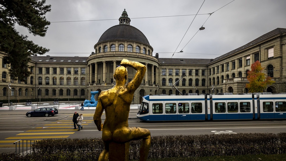 Personen gehen vor dem Hauptgebaeude der Eidgenoessischen Technischen Hochschule (ETH) und der Skulptur "Der Genesende" von Otto Charles Baenninger, in Zuerich, am 30. November 2024. .(KEYST ...