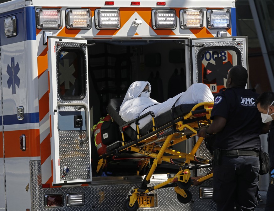 epa06999558 A passenger from Emirates Flight 203 from Dubai that landed at JFK International Airport this morning is transported on a stretcher by paramedics to an ambulance at terminal four in JFK In ...