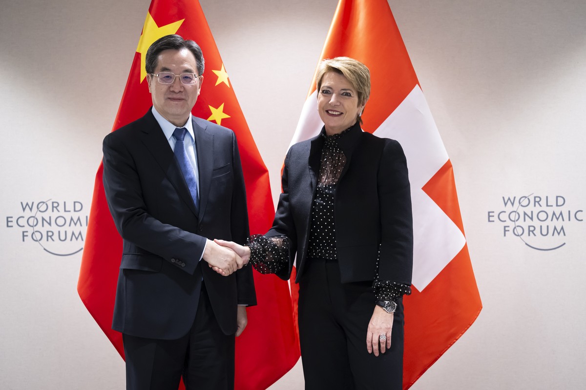 epa11842132 Swiss Federal President Karin Keller-Sutter (R) shakes hands with China's Vice Premier Ding Xuexiang (L) after their bilateral meeting on the sidelines of the 55th annual World Econom ...