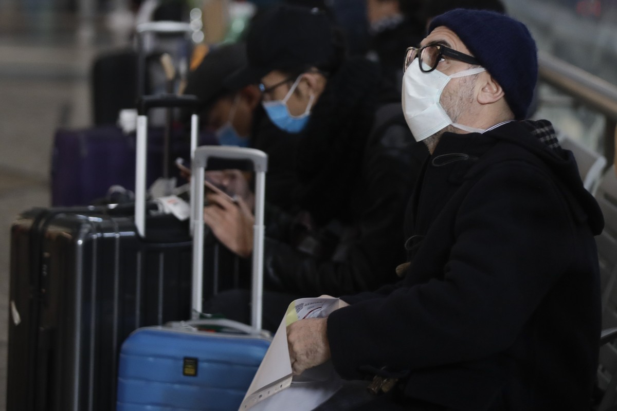 People wearing sanitary masks sit as they wait at the Centrale main railway station in Milan, Italy, Monday, Feb. 24, 2020. Italy has been scrambling to check the spread of Europe's first major o ...
