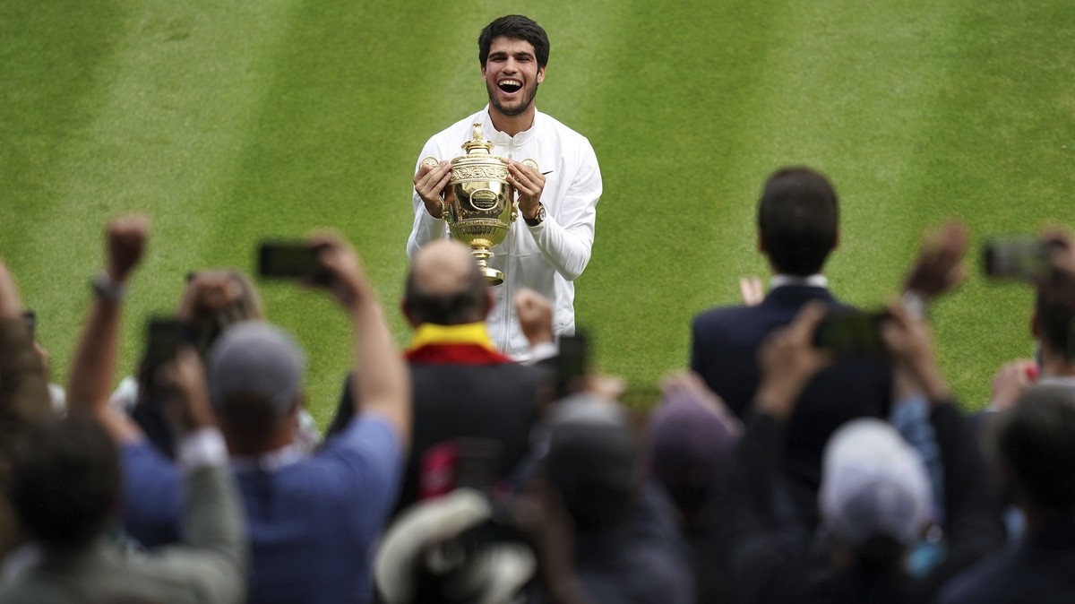 Spain's Carlos Alcaraz celebrates with the trophy after beating Serbia?s Novak Djokovic to win the final of the men?s singles on day fourteen of the Wimbledon tennis championships in London, Sund ...