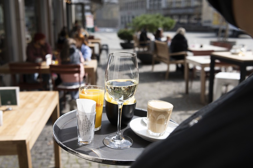 Capucino, Prosecco und Organgensaft auf dem Tablett einer Kellnerin der Bar Blumenmarkt im wiedereroeffneten Aussenbereich, fotografiert am 19 April 2021 in St. Gallen.(KEYSTONE/Christian Beutler)