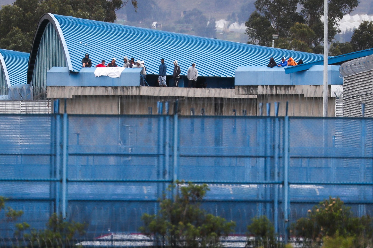 epa11068282 Inmates remain on the roof of the Sierra Centro Norte Cotopaxi Social Rehabilitation Center, in Latacunga, Ecuador, 10 January 2024. The President of Ecuador, Daniel Noboa, assured that hi ...
