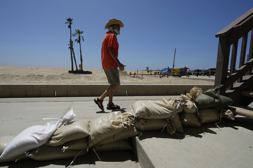 Seal Beach resident Tom Ostrom, walks past a home protected with sandbags in Seal Beach, Calif., Friday, Aug. 18, 2023. Hurricane Hilary is churning off Mexico&#039;s Pacific coast as a powerful Categ ...