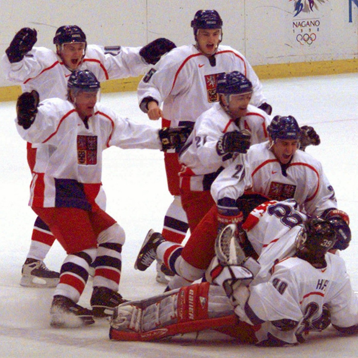 Czech Olympic Hockey team members pile on to goaltender Dominik Hasek after defeating Canada, 2-1, in a sudden death overtime shootout in their semi-final match in Olympic men's hockey in Nagano, ...