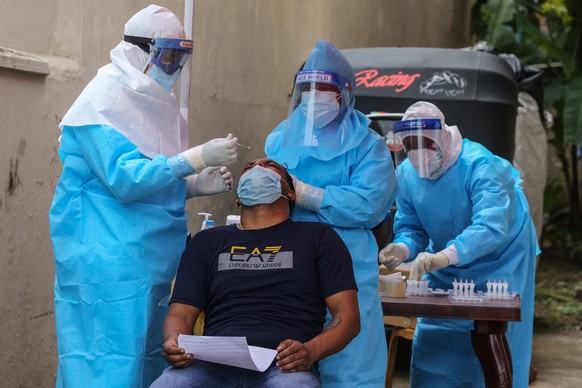 epa09491189 A construction worker undergoes a COVID-19 swab tests at a temporary test facility amid the coronavirus disease (COVID-19) pandemic in Colombo, Sri Lanka, 27 September 2021. According to S ...