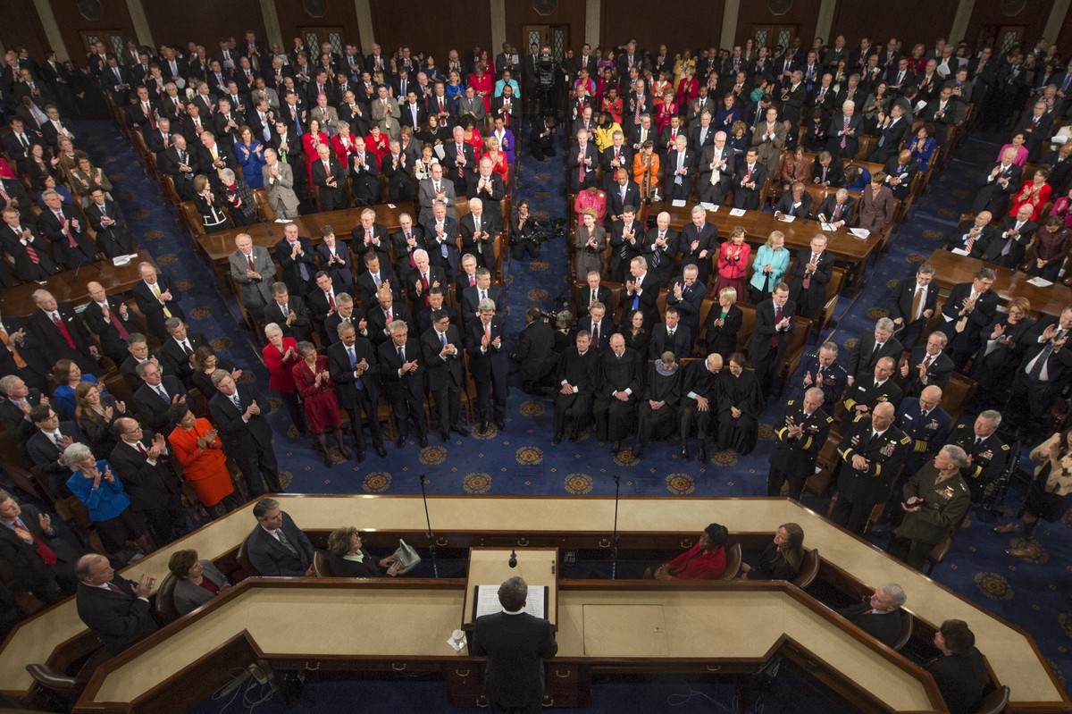 epa04046262 US President Barack Obama (C) receives a standing ovation while delivering his State of the Union address before a joint session of Congress, on Capitol Hill in Washington DC, USA, 28 Janu ...