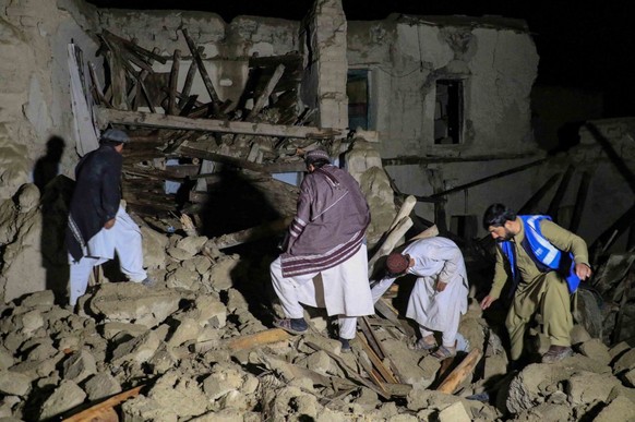epa10028437 Rescue workers and local residents survey a damaged house after an earthquake in Gayan village in Paktia province, Afghanistan, 22 June 2022. More than 1,000 people were killed and over 1, ...
