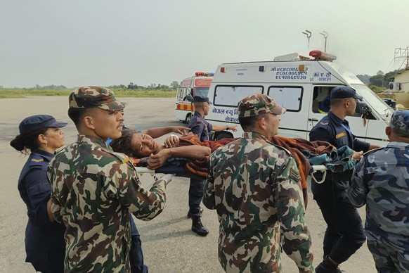 A woman flown from an earthquake-hit area is carried on a stretcher in Nepalgunj, Nepal, on Saturday, November 4, 2023.  A strong earthquake has shaken northwestern Nepal, and officials say more than…