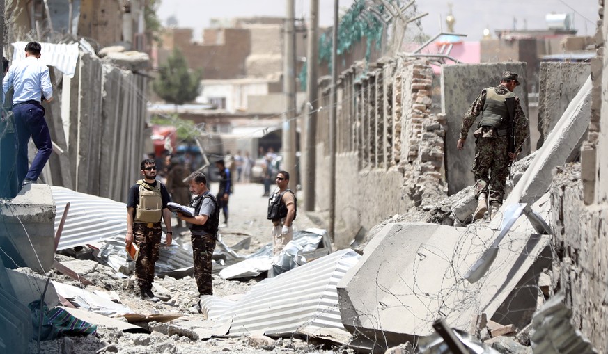 epa07760020 Afghan security forces officers stand guard at the site after a truck bomb explosion followed by gun fight targeted a police station in a heavy residential area in the west of Kabul, Afgha ...