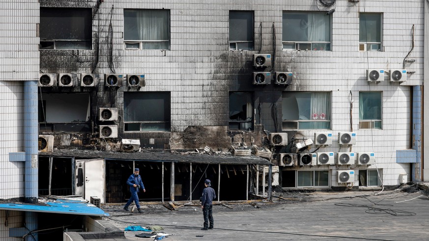 epa10579589 Investigators inspect the scene following a fire at the Changfeng Hospital in Beijing, China, 19 April 2023. At least 21 people died following a fire at the Changfeng Hospital in the Fengt ...