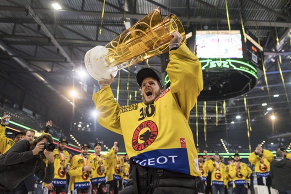 Der Berner Goalie Leonardo Genoni stemmt den Meisterpokal und feiert mit seiner Mannschaft als Eishockey Schweizermeister nach dem sechsten Eishockey Playoff-Finalspiel der National League A zwischen  ...