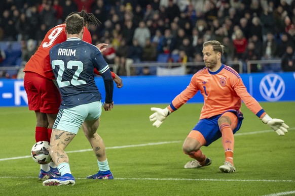 epa12855237 Switzerland's Johan Manzambi, left, against Germany's David Raum, center, in front Germany's goalkeeper Oliver Baumann, right during a friendly soccer match between Switzerl ...